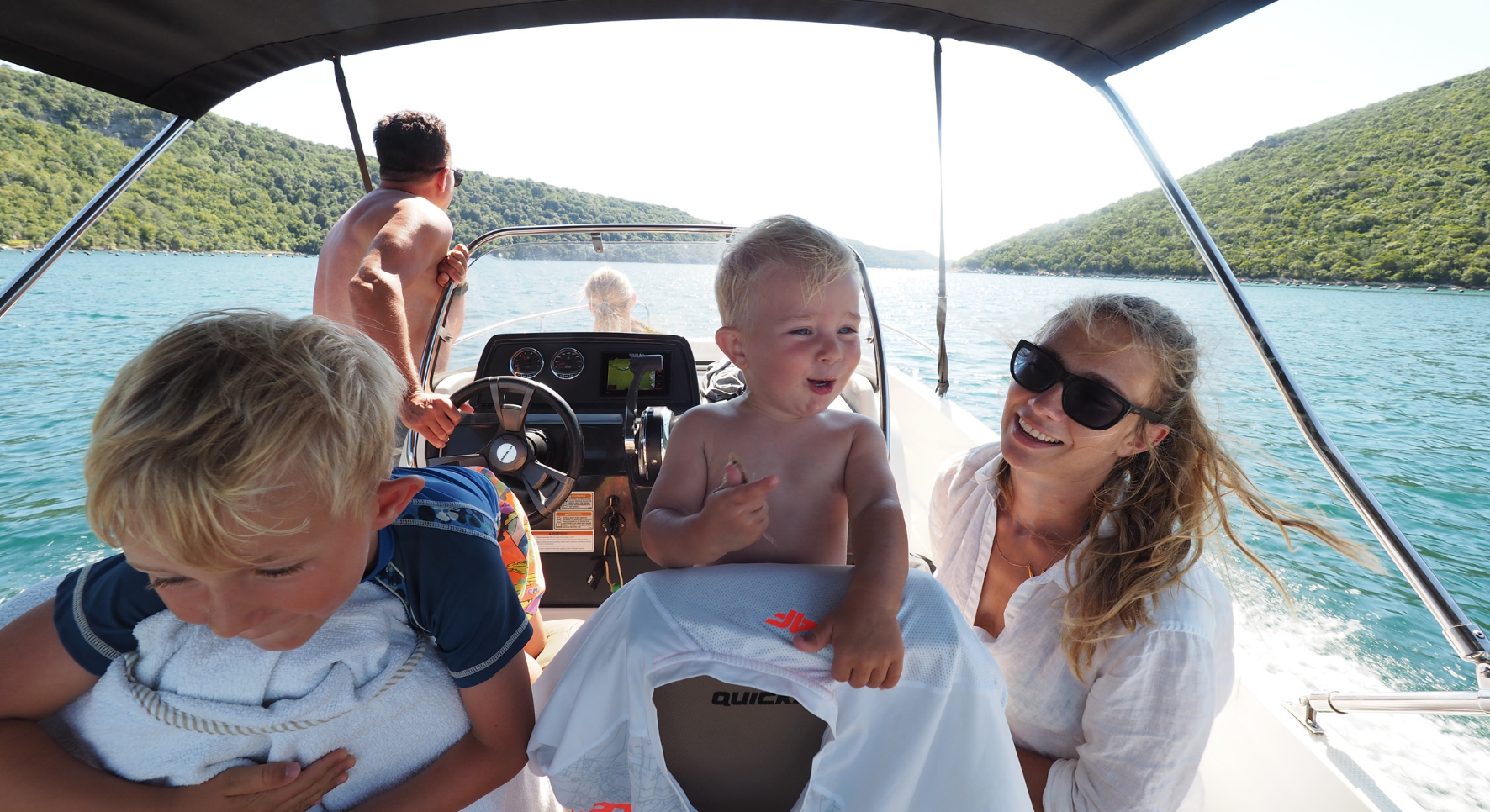 Fishing boat with small front cabin, wooden helm and rain canopy on back  tied to a mooring pillar in Croatian harbor Stock Photo